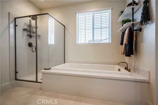 First primary en-suite bathroom ffboasts a soaking tub, and walk-in shower. Window above the tub allows for natural light.