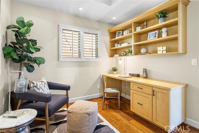 Bedroom on main level (staged as an office) with built in desk and shelving