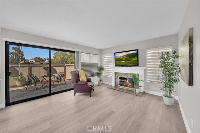 Inviting Family Room has Granite Fireplace with Handcrafted White Wood surround and Mantel, Plus Sliders Leading to Private Backyard Patio