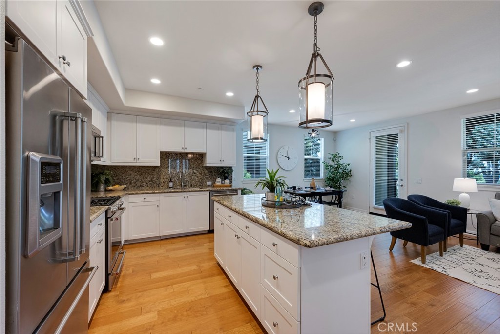 Kitchen is complete with shaker style White Cabinetry, Large Center Island with bar top seating, and Stainless Steel Appliances.