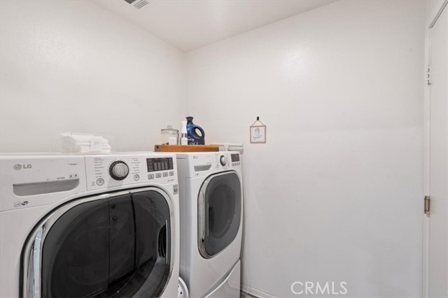 Laundry Room adjacent to spacious 2 car garage with custom cabinets and storage.