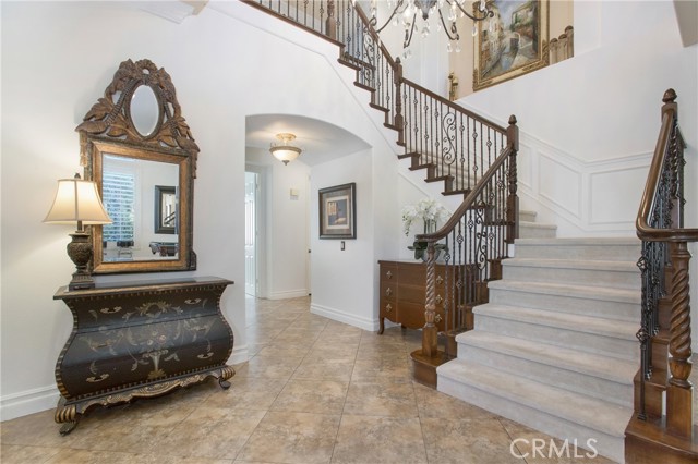 Inviting entry with custom staircase and wainscotting