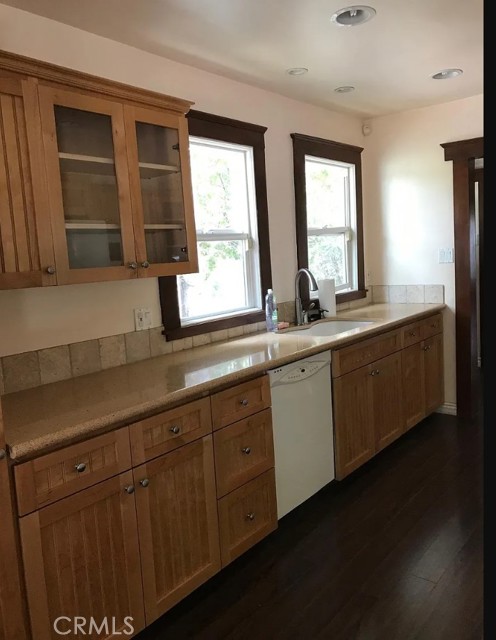 Updated galley kitchen with beautiful shaker cabinets with glass front doors.