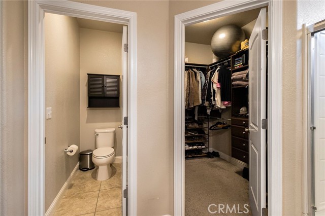 Primary ensuite with toilet closet and walk in closet with custom shelving.