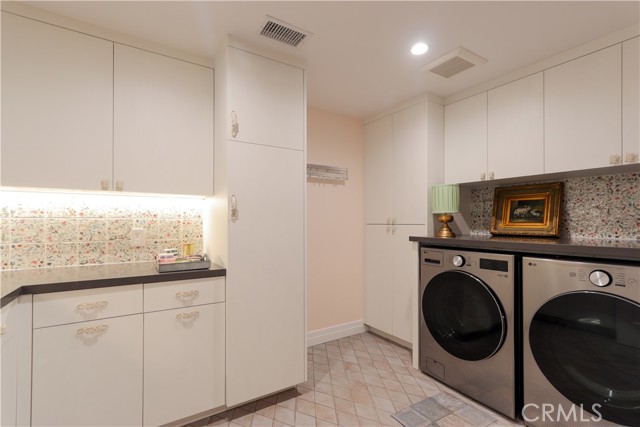 The impressive laundry room has substantial storage for today\'s busy family. Cheerful designer tile accents and yes, the sleek washer and dryer set is included!