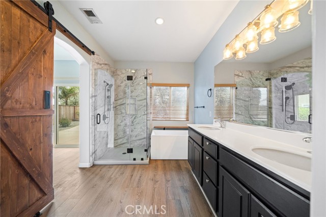 Wow! Spa-like primary bathroom with a wonderful barn door for privacy!