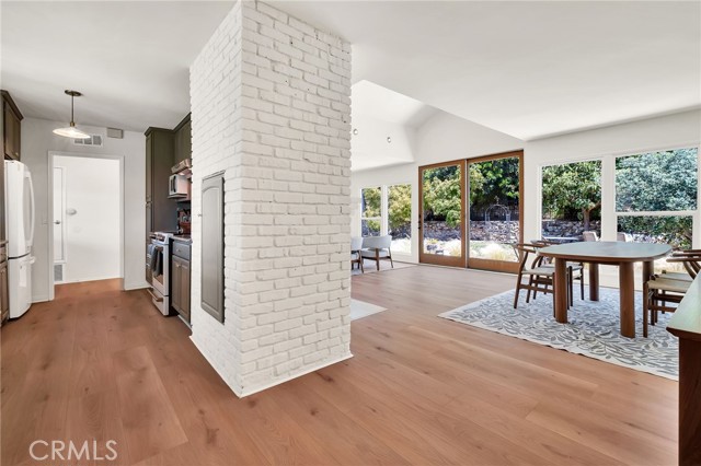 living room with fireplace next to kitchen and lots of windows to backyard