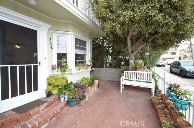 The lower unit has a lovely entrance with a brick patio and room for all your potted plants.