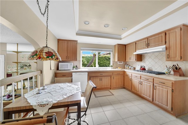 Large Country-Style Kitchen with Recessed Lighting, Tile Countertops, an Abundance of Natural Wood Cabinetry, and an Eat-In Breakfast Nook