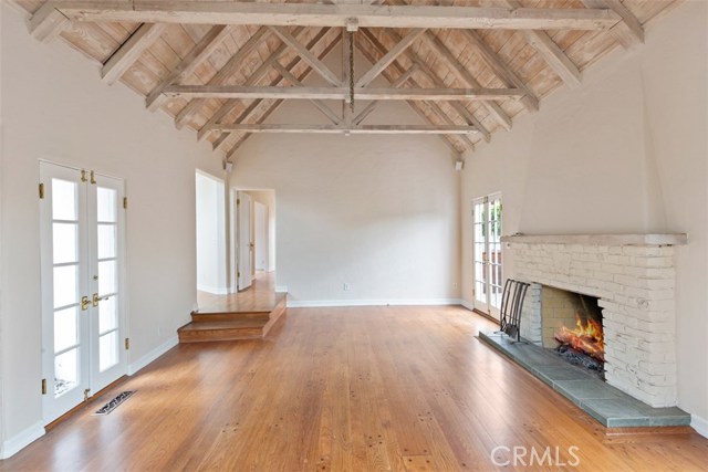 STEP DOWN TO LIVING ROOM WITH CUSTOM FIREPLACE AND BEAM CEILINGS