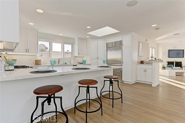 from balcony looking at kitchen towards wet bar and living room, note fireplace in living room