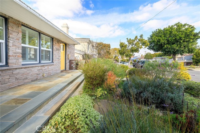 Stone tile front porch overlooking serene front garden