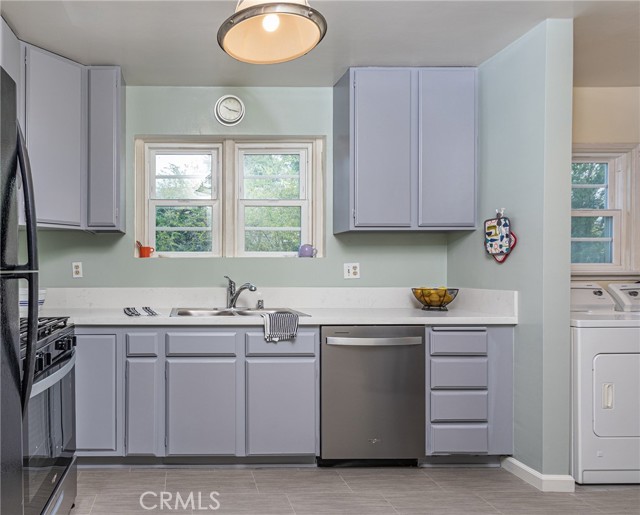 The updated kitchen with stainless steel  appliances, white quartz countertops, new sink, and stylish wood cabinets.