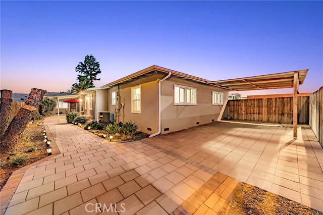 Paved backyard with side patio and back patio