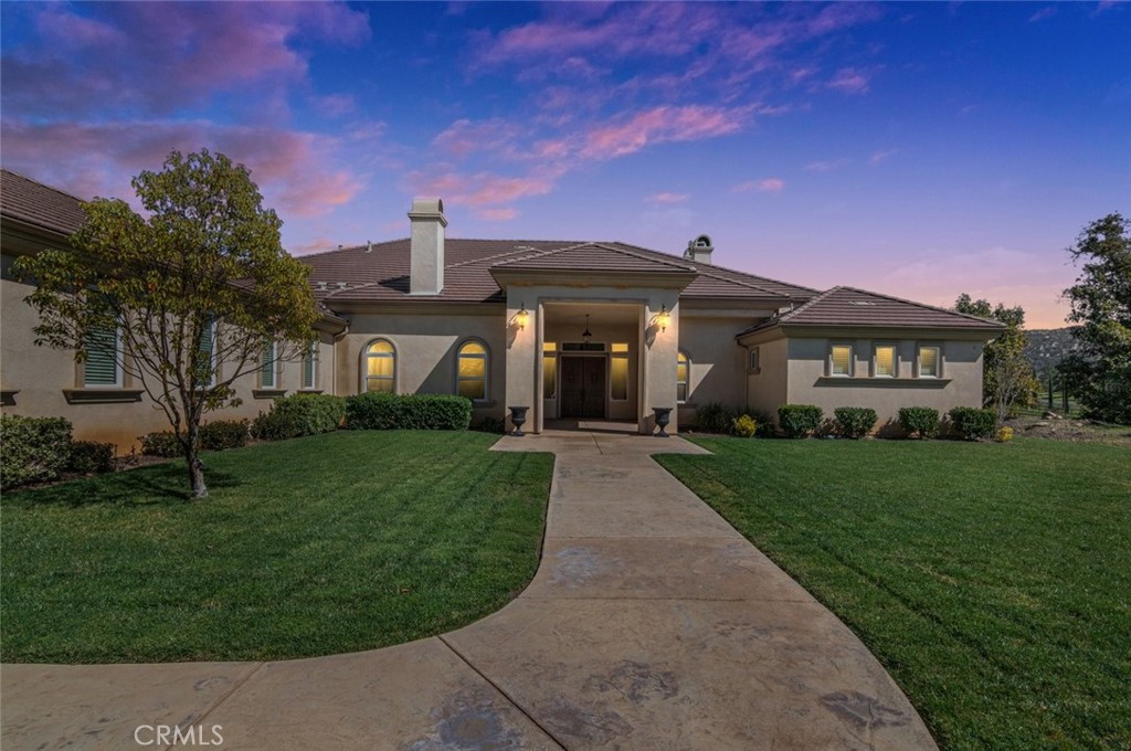 28270 Via Santa Rosa Temecula, California Enjoy glorious outdoor evenings reminiscent of warm Tuscan nights in this luxurious single story estate nestled in the hills of De Luz with lush gardens and orchards. This entertainer's delight offers a custom kitchen and great room with soaring high ceilings and fireplace as well as multiple doors to the California room and private patios. SEE 3D WALK THOUGH TOUR. The kitchen features Dacor stainless steel appliances & Granite counters & display cabinets. Rolling lawns lead to a dramatic Portico entryway. The opulent dining room with dual french doors to the front yard, stunning chandelier, tray ceilings and fireplace. The Master suite in a private wing features a fireplace and french door to a private patio. The bathroom is natural tile with a dual showerhead shower & a jacuzzi tub. There is an office with a private entry and high speed line of sight internet which is a huge bonus in De Luz. There are 4 additional oversize bedrooms, two with a Jack & Jill bathroom. Both secondary bathrooms feature natural stone tiled showers surrounds and granite countertops. There are gentle walkways to the outdoor entertainment area with pizza oven and outdoor kitchen as well as a custom fireplace & patio. There is a tournament size bocce ball court, raised bed, cottage shed, custom hen house and fabulous mountain view. Nearly three acres of the property are planted with persimmon and avocados. Can be sold furnished. The family orchard includes variety of trees. The home is 5 minutes to the bustle of Old Town or the freeway.