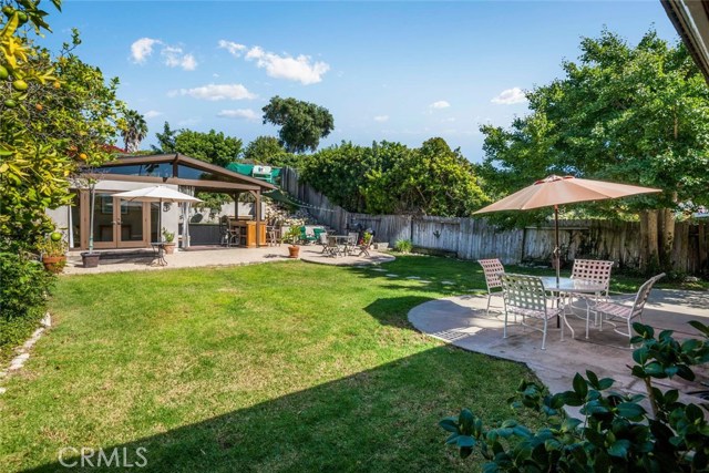 Large grassy area with hardscape patio and guest house in the back.