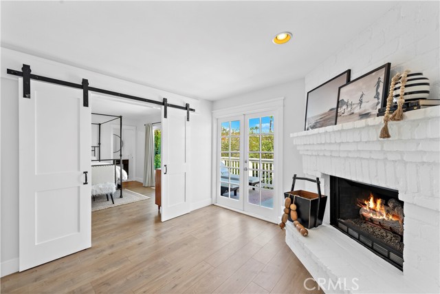 Fireplace at top of stair landing with French doors leading to backyard balcony with peek a boo ocean views.