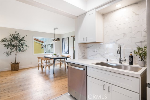  Shaker style cabinets and subway porcelain tile backsplash and stainless steel sink and appliances.