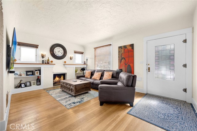 Comfortable South facing living room with gas fireplace, built-ins, coved ceilings and great Southern exposure