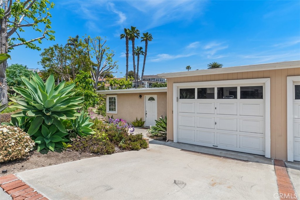 Rare opportunity close to downtown Dana Point! Tucked into a serene corner of this coastal community, this charming single-level end unit beach cottage blends relaxed elegance with modern design. Remodeled and brimming with natural light, the open-concept layout offers 3 spacious bedrooms, 2 updated bathrooms, and approximately 1,185 square feet of inviting living space. Soaring vaulted ceilings and clerestory windows enhance the airy atmosphere in the living room, where a newly updated fireplace serves as the cozy focal point. The stylish kitchen opens directly to the main living and dining areas, creating a seamless flow perfect for entertaining or relaxed everyday living. The primary bedroom with en suite bathroom is spacious and bright with floor to ceiling windows. Dual sinks and beautifully remodeled walk in shower in the guest bathroom and also has ample counter space. Outside, a private backyard awaits with nice patio cover, pavers and hardscape with minimal maintenance. The community greenbelt is just beyond the backyard and sits perfectly within the community for added privacy. With its fresh coastal aesthetic, thoughtful updates, and an ideal single-level layout, this beachside gem is the perfect retreat to call home. Incredibly close to downtown shops, restaurants, and beaches.