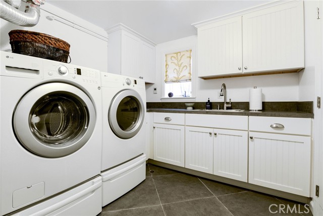 Oversized full laundry room with plenty of space... sink, shelving, folding area and closet for storage