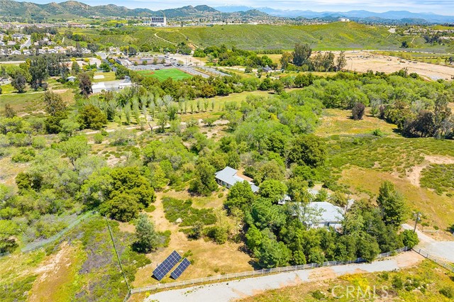 ONE IN A MILLION OPPORTUNITY!  …TWO HOMES AND A RUNNING CREEK ON THIS 3.41-ACRE OASIS IN A SHOCKINGLY CONVENIENT LOCATION!  Be one of only a few fortunate homeowners to own a residential retreat with acreage off the convenient, centrally located Clinton Keith Road on the border of Wildomar and West Murrieta at the base of the Santa Rosa Plateau. Not only is this a beautiful and usable wonderland for agriculture, horses, playgrounds, etc, but it is full of mature trees and hosts a creek with year-round running water, inspiring sights and sounds which are simply spellbinding. Just moments from the 15 Freeway and every convenience of town (literally 3 minutes to restaurants, schools, and shopping), you will enjoy all the benefits of city living, while being able to, within minutes, retreat to your private natural sanctuary. Sit quietly and listen to the sounds of running water and local wildlife, who come to feed at the babbling brook right on property every day. This unique property includes TWO HOUSES!  Live in one and rent the other, rent them both, or make both homes a part of your personal retreat. HOUSE 1: 1270 sf with 2 bedrooms and 2 bathrooms. HOUSE 2: 1074 sf with 2 bedrooms and 2 bathrooms. Both homes have new 2023 roofs, large covered patios with 50-Amp electrical outlets, water filtration systems, electrical performance meters, wifi irrigation timers, and other thoughtful amenities to keep energy costs low . Shared by both homes are an RV hookup, paid-for solar with new inverter, excellent water well with new pump, whimsical walking paths, and a picturesque scene straight from a Hallmark movie – a sitting area under the canopy of a massive ancient oak tree next to the running stream. Keep this charming property as it is or build your dream house, as you let the land and nature speak to your soul. As an added bonus, if you can tear yourself away from this haven, drive just a few minutes up the hill to the 1000s of acres of the Nature Reserve and hiking trails of the Santa Rosa Plateau. This magical property must be experienced with all of your senses to be believed!  *****Note that you may enter Jerome Lane through the adjacent neighborhood if you want to avoid Rancho Mirlo (dirt road off Clinton Keith). Nearby are schools, restaurants, hospitals, grocery stores,15 Fwy & the famous Temecula Wine Country. …All less than 1.5 hours from LA, SD, OC, Palm Springs & Big Bear.