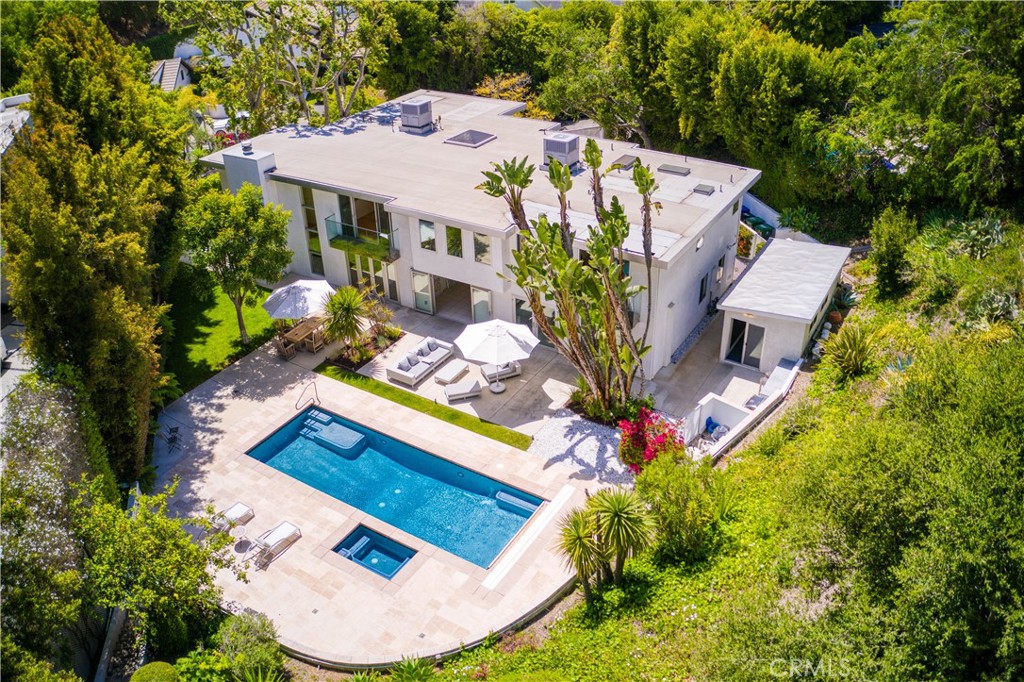 Contemporary, elegant architectural gem. Masterfully redesigned and rebuilt in 2009, this stunning two story gated 5,200 sq foot home is located in lower Bel Air, is a resort unto itself offering serenity & complete privacy.
 
The spacious kitchen, adjacent & open to the family room, features built-in cabinetry, top grade Viking and Thermador appliances, built-in microwave and a large marble and sandstone island with a generous breakfast bar with seating for six. Perfect for entertaining, the double set of Fleetwood doors open up to a luscious private expansive two level backyard complete with its own private fruit orchard and a 36 foot lap-swimming pool with cover and  jacuzzi, a marble bar, BBQ and an adjacent 250+ sq foot mirrored pool house/gym with its own private bathroom.  Adjoining the family room is an en suite bedroom with its own full bathroom perfect for guests, a live-in or as a private office next to the laundry room. Breathtaking 20+ feet soaring ceilings open from the foyer to the formal living area, with a dramatic contemporary staircase leading up to the second floor, give this home palatial flair. Adjacent to the living-room on the main floor, is a wine room with wine storage and two Vinotemps 48 bottle wine coolers, additional copious shelf storage and a guest powder room.  On the second floor, the spa-like primary suite and three additional en suite bedrooms with their own private bathrooms with large Fleetwood windows bathe in natural sunlight. An open loft offers stunning views of the lush garden & grounds below. A separate office space with extensive cabinetry with access to a large private balcony and an additional separate bathroom complete the upstairs living area. The home offers plenty of closet & storage space throughout, including a walk-in closet in the primary suite. There is ample parking on the property with space for up to 6 cars, including a 2-car garage.
 
The backyard oasis, a thoughtfully designed blend of natural stone & grassy lawn, is surrounded by shrubs & trees. An orchard, private guesthouse, large pool with automatic cover system and jacuzzi, designated BBQ space with dining area, an anti-nuclear shelter, and a playset are just some of the luxurious features that transform backyard parties into classy outside experiences.  
 
This property may also be leased furnished (inquire for price)
