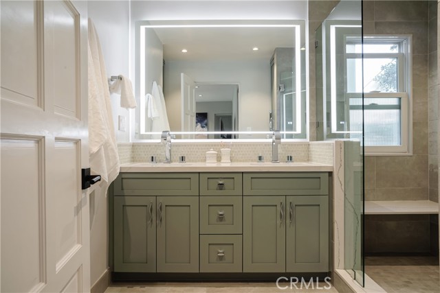 Primary bathroom with custom cabinets and 60x40 lighted mirror