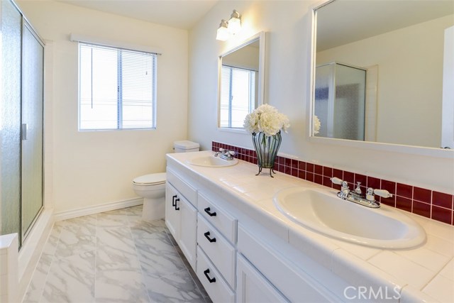 Full bathroom with separate tub and shower in the hallway across from the bedrooms.