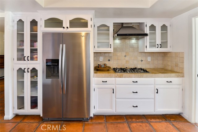 Stainless steel refrigerator (included in sale) and the stove with stainless steel hood.