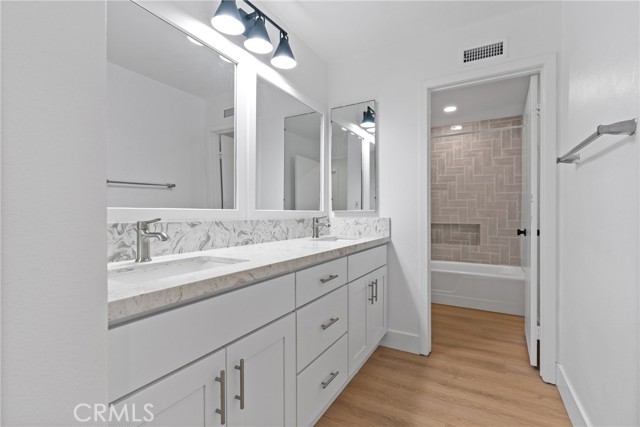 Updated Secondary Bathroom with dual sinks, new lighting fixtures, shower tile, refinished tub and new toilet. All permitted by the city of Lake Forest.