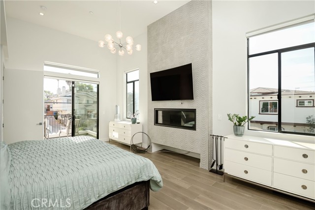 Primary bedroom with fireplace and balcony