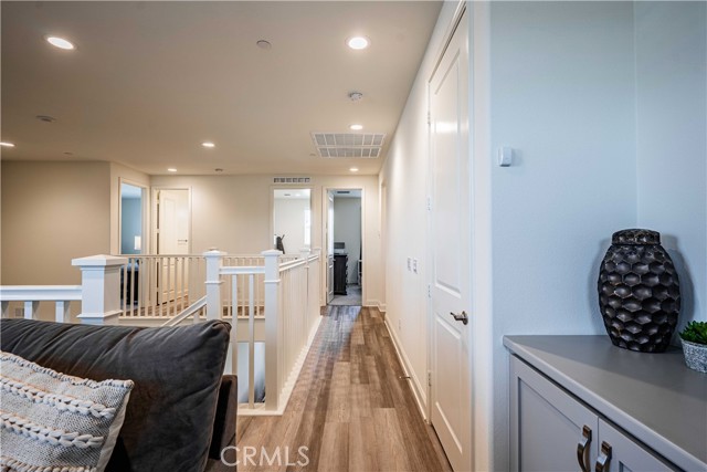 Upstairs walkway from the loft/First primary to the 3 other bedrooms. A well thought out floor plan for sure!Nice loft cupboards space tucked nicely here before the first primary bedroom doorway.