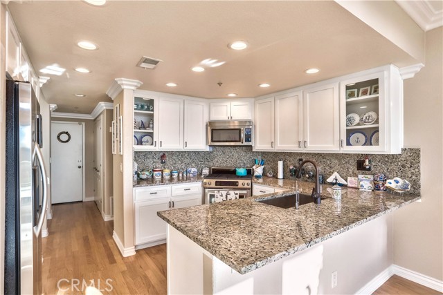 The kitchen has been fully remodeled with updated white cabinetry, stainless steel appliances, farmhouse sink, touch faucet and more.