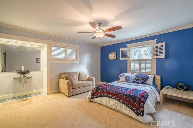 Guest bedroom with boarding house wash basin placement updated ceiling fan and plenty of exterior natural light and air.