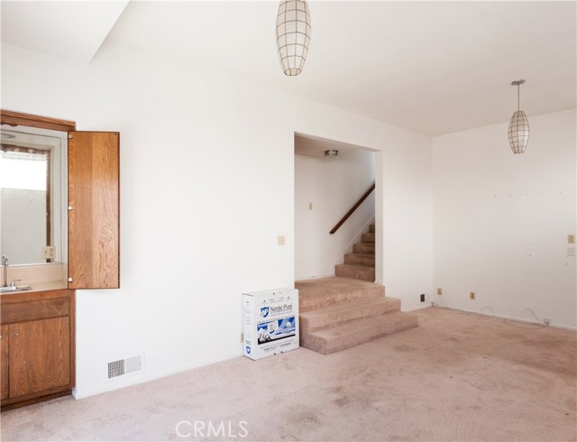 Taken from family room corner looking at wetbar and staircase up (6 steps) to entry. Go up the 3 stairs and left takes you to the 2 bedrooms and bathroom.