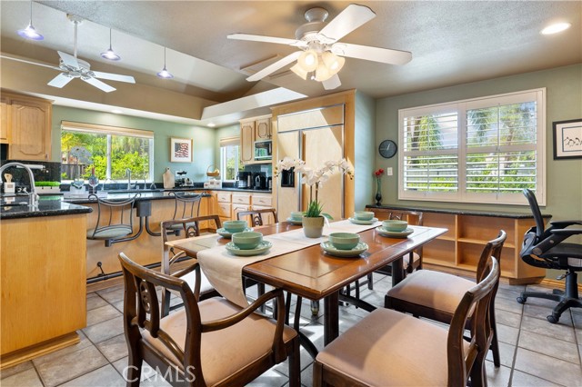 This is a very spacious area for casual dining in the kitchen. The table shown is for six but space for eight easily. Built in shelves below the double pane window to store decor or cookbooks or games. Chair to the right of the image is at a built in desk area with cabinets.