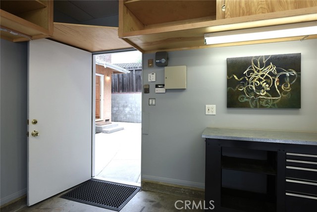Looking through 2-car garage's door; front door-bell chime; double-gang electrical outlets; cabinetry on three sides