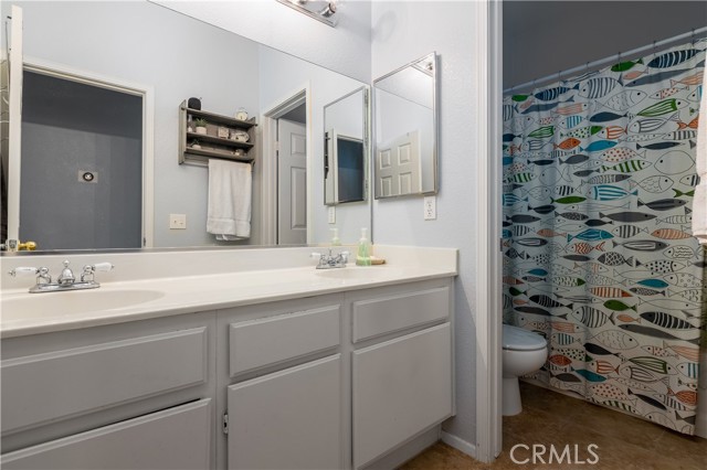 Secondary bathroom with double sink vanity.