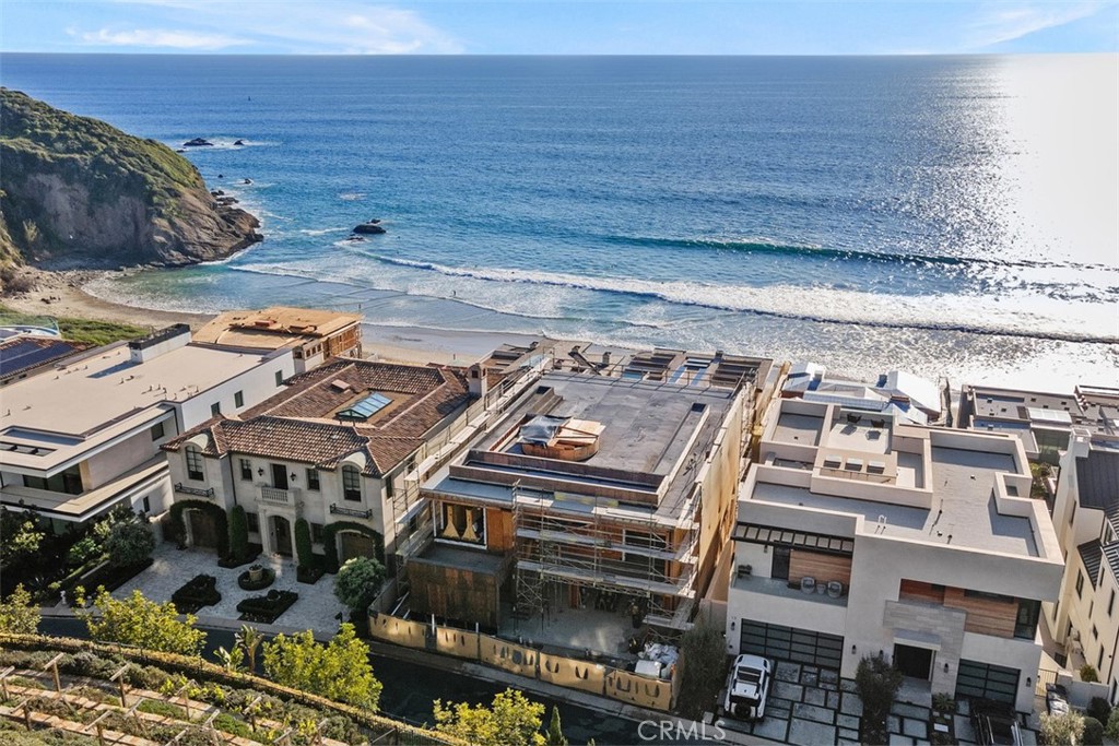 Be the first to experience the joys of living, entertaining and relaxing at this modern ocean-view masterpiece behind the guarded entry gates of The Strand at Headlands in Dana Point. Under construction and scheduled for completion in early 2025, the light-filled custom residence presents a prized second-row location that affords stunning Pacific Ocean, Catalina Island, sunset and beach views from four levels, which include a rooftop patio with kitchen and open-air fireplace. A testament to sophisticated modern architecture showcasing the talents of Geoff Sumich Design, Tiffany Harris Design and built by Genova Construction, the exceptionally designed home will welcome all with a phenomenal foyer centered around a floating circular staircase that accesses all levels. An elevator is also featured, and high-end natural stone and wood finishes, custom-caliber lighting and plumbing fixtures, and wide open proportions combine to create a refined living environment. Approximately 8,237 square feet, the generous floorplan includes six ensuite bedrooms, an ensuite office, seven full baths and two half baths. The main entry level showcases an open design with a dining room, massive living room with high ceiling, a fully appointed island kitchen and a secondary butler’s pantry/catering kitchen. This entire space opens to an ocean-view deck via slideaway glass doors. Bedrooms are located on the third floor, complete with a luxurious primary suite that will reveal an entry vestibule with coffee bar, an ocean-view deck, sitting area, walk-in closet, soaking tub, separate shower and two vanities. Play, refresh and reinvigorate on the lowest level, which hosts a gym with bath, a walk-in bar, play/media room, and an after-swim changing room. Slideaway glass doors open to a terraced ocean-view backyard with pool and spa. Additional highlights will include a three-car garage, golf cart garage, two laundry rooms, and rooftop planters. The Strand at Headlands is one of the most coveted oceanfront communities in California and offers more than one mile of coastline, 70 acres of parks, scenic trails, a beach club and easy access to resorts, shops, restaurants and outstanding schools.