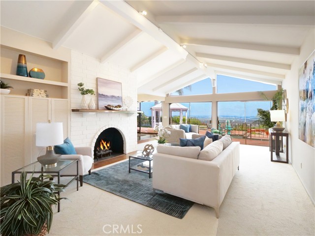 Living room with white brick fireplace and high beam ceilings