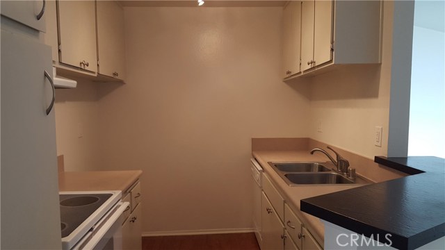 Kitchen has laminate wood floors and newer formica counter tops with stainless steel sink.