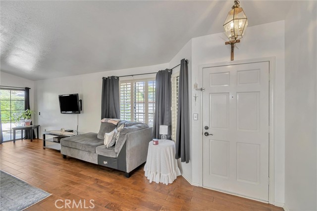 Living area with beautiful wood floor and shutters