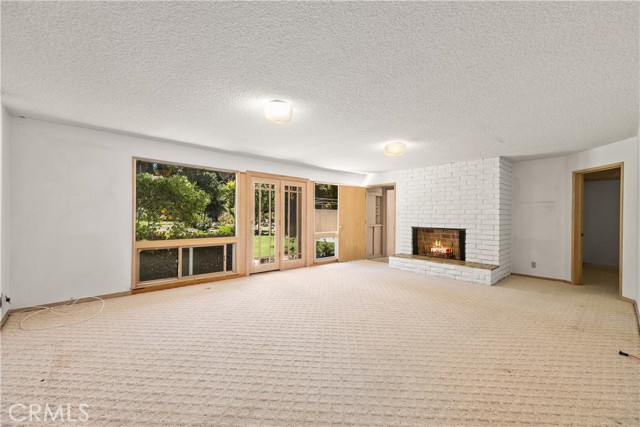 Downstairs family room. Fireplace. Opens to back yard.  Side door leads to covered patio.