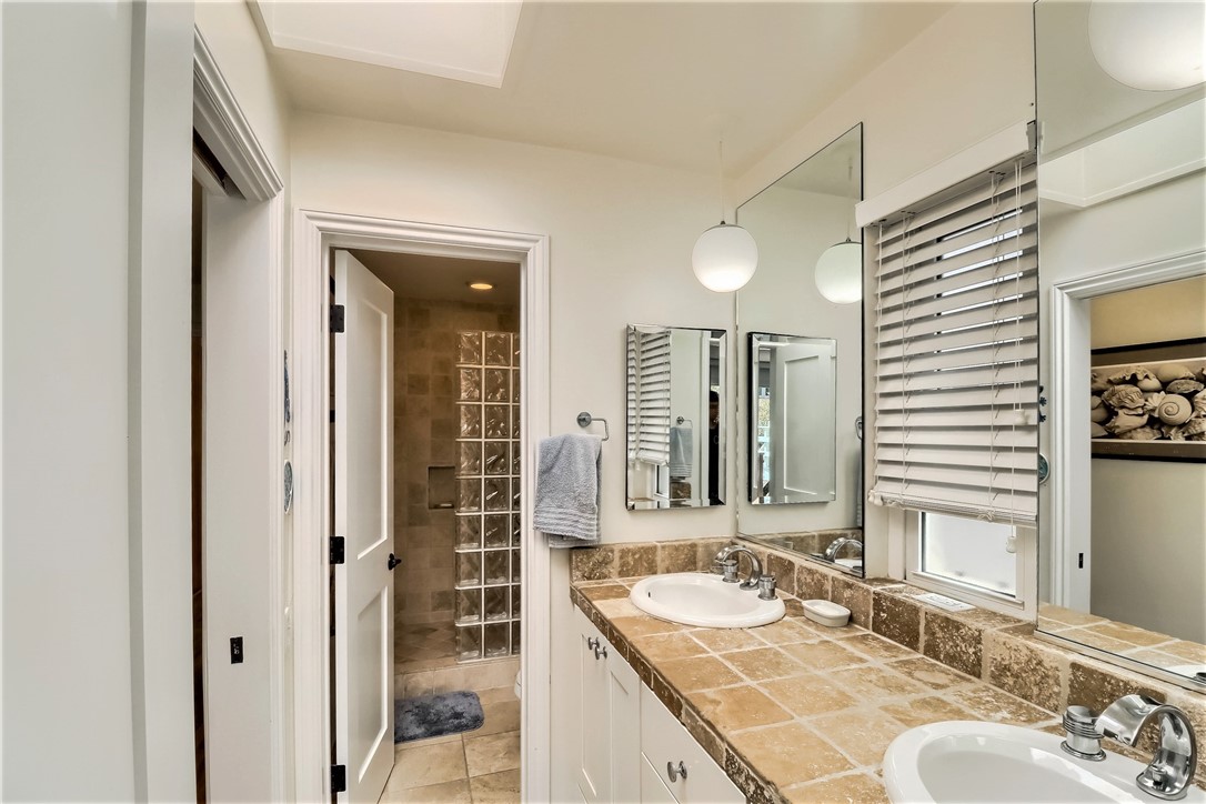 The Large Master Bathroom has a Large Vanity with Abundant Storage and Double Sinks. There is a Custom Designed Shower and Stone Floors.