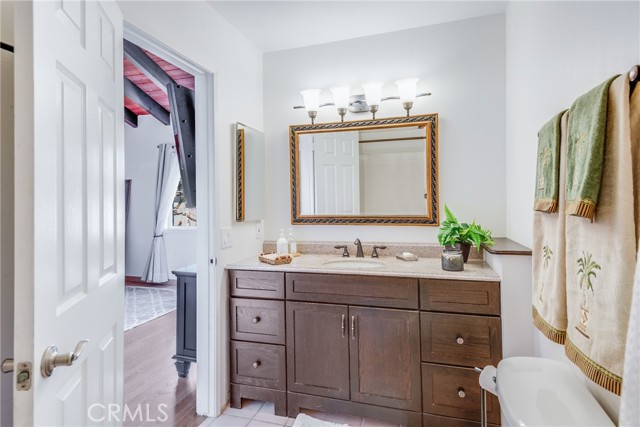 Primary bath with rich cabinetry, newer lighting, mirror, shower and more