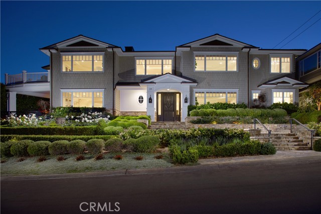 Poised at the end of an elevated cul-de-sac in Newport Beach’s highly coveted Cliffhaven enclave, this newly upgraded custom residence offers panoramic Newport Harbor, turning-basin, Pacific Ocean, Fashion Island, city-light and mountain views. Unparalleled curb appeal makes a grand first impression and is embellished with mature and manicured landscaping that complements the estate’s New England Shingle-inspired architecture. Sprawling grounds on the oversized homesite reveal sunny patios, stone terraces and a courtyard with spa, built-in BBQ, and a fire pit with built-in seating. Approximately 7,567 square feet, the two-level residence presents six ensuite bedrooms and is intelligently designed to maximize views by placing main living areas on the top level. Centered around a graceful spiral staircase, the first level showcases a foyer with classic Dutch entry door, a stunning wood-paneled executive office with coffered ceiling, a bright and spacious fireplace-warmed great room with kitchenette and wet bar, a wine cellar, and three bedrooms including a secondary primary suite with double doors, a fireplace, walk-in closet and soaking tub. Many spaces on this level open to the private courtyard. Crowned by skylight, the spiral staircase is joined by two additional staircases and an elevator that provide passage to the upper level, where memorable formal and casual gatherings are sure to be remembered by all who attend. The living and dining rooms are generously sized, and the family room and kitchen area is illuminated by large view-enriched windows. Anchored by a massive marble-topped island, the new chef-caliber kitchen displays white cabinetry, a built-in desk, two sinks, and top appliances including a Wolf range and a built-in refrigerator. The butler’s pantry boasts a Miele coffee station, a warming drawer and a beverage refrigerator. Sequestered behind double doors in its own second-floor wing, the primary suite features a fireplace, soaking tub, sit-down vanity, two water closets, and an oversized cedar-lined dual-entry walk-in closet with safe and washer/dryer set. Enjoy fireside gatherings on the roof-top deck, where 360-degree views are without equal. Lutron lighting, a multi-camera security system, handcrafted millwork, stone fireplaces, newly finished hardwood flooring, new luxury carpet, fresh paint, and an oversized tandem 4-car garage with golf cart stall and private entry lend added appeal.