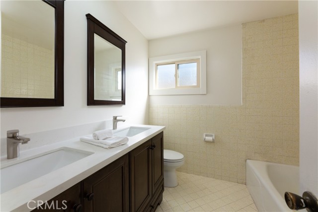Full bathroom on upper level with new vanity and mirrors.