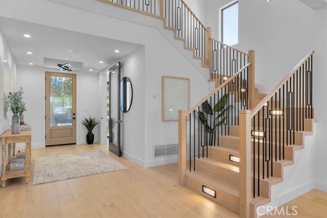 Beautifully lit stairs lead to 4 en-suite bedrooms, laundry room, and sitting area upstairs
