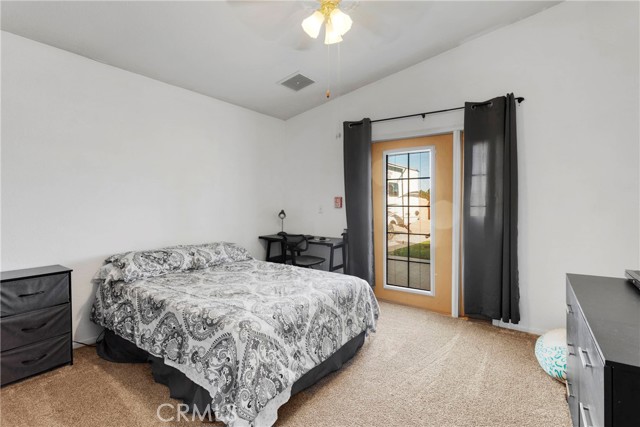 Guest bedroom 2 with French door leading to backyard